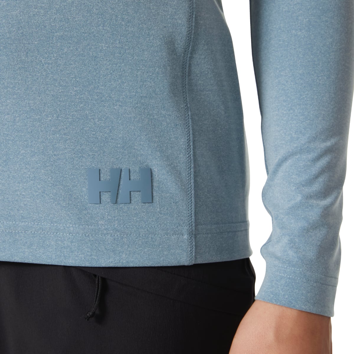 Close up of the hoodie hem with the HH logo on Washed Navy Melange fabric.