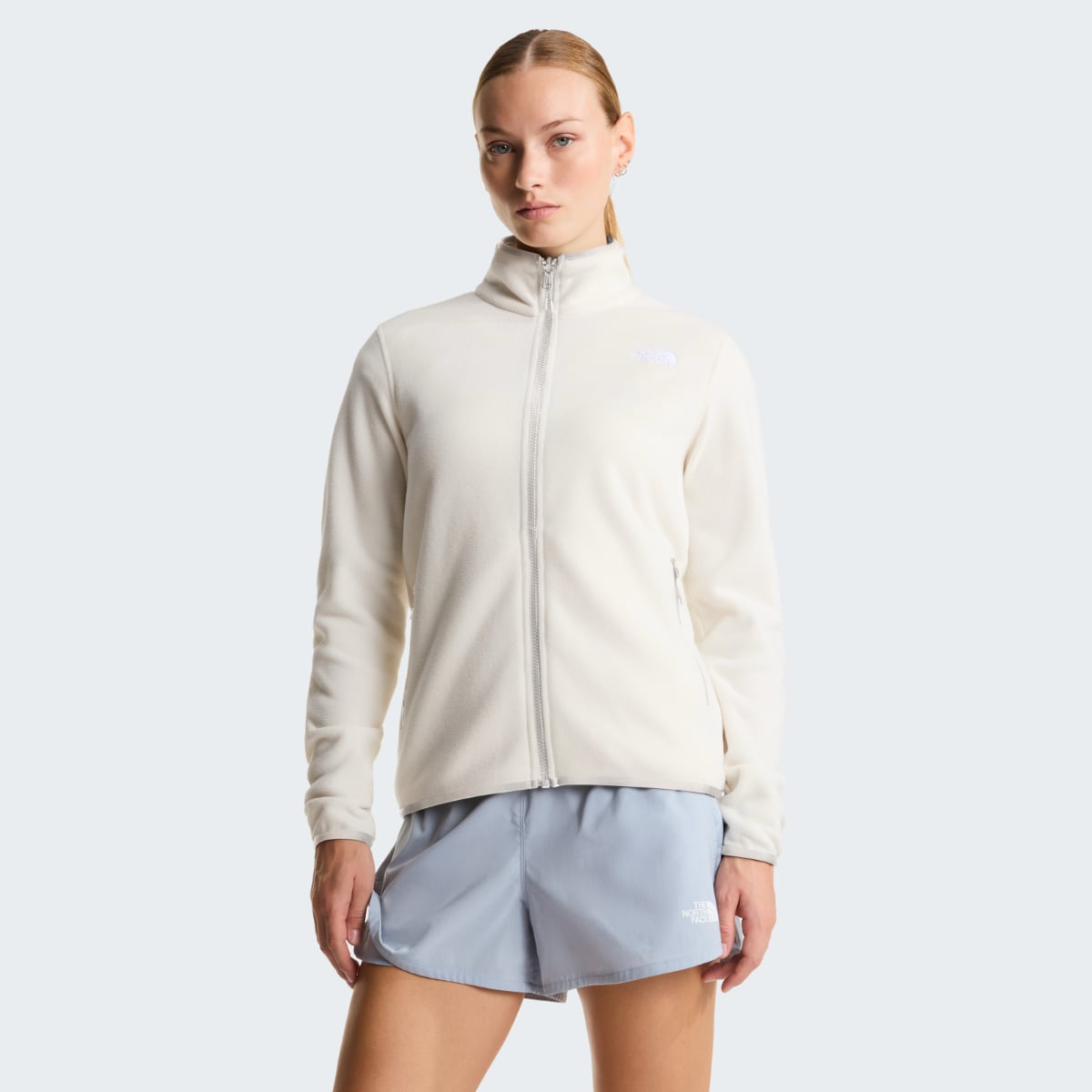 Model wearing The North Face Glacier Fleece Women's Jacket in White Dune with zip front and stand collar.