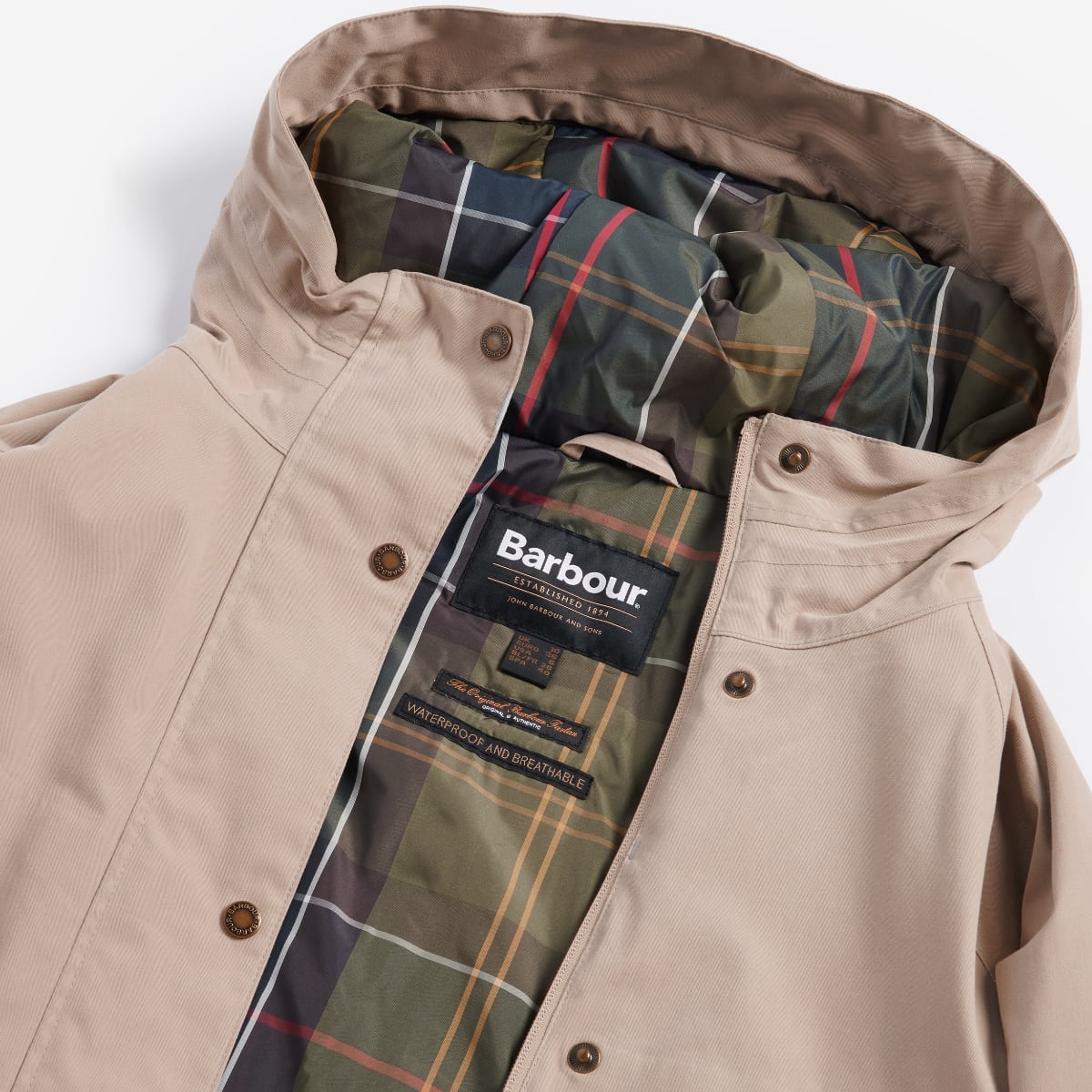 Close up of the beige Barbour Beadnell jacket unzipped to show plaid interior lining and brand label.