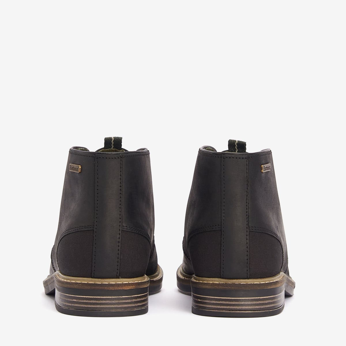 A rear view of a pair of black Barbour Readhead Men's Chukka Boots displayed against a white background.