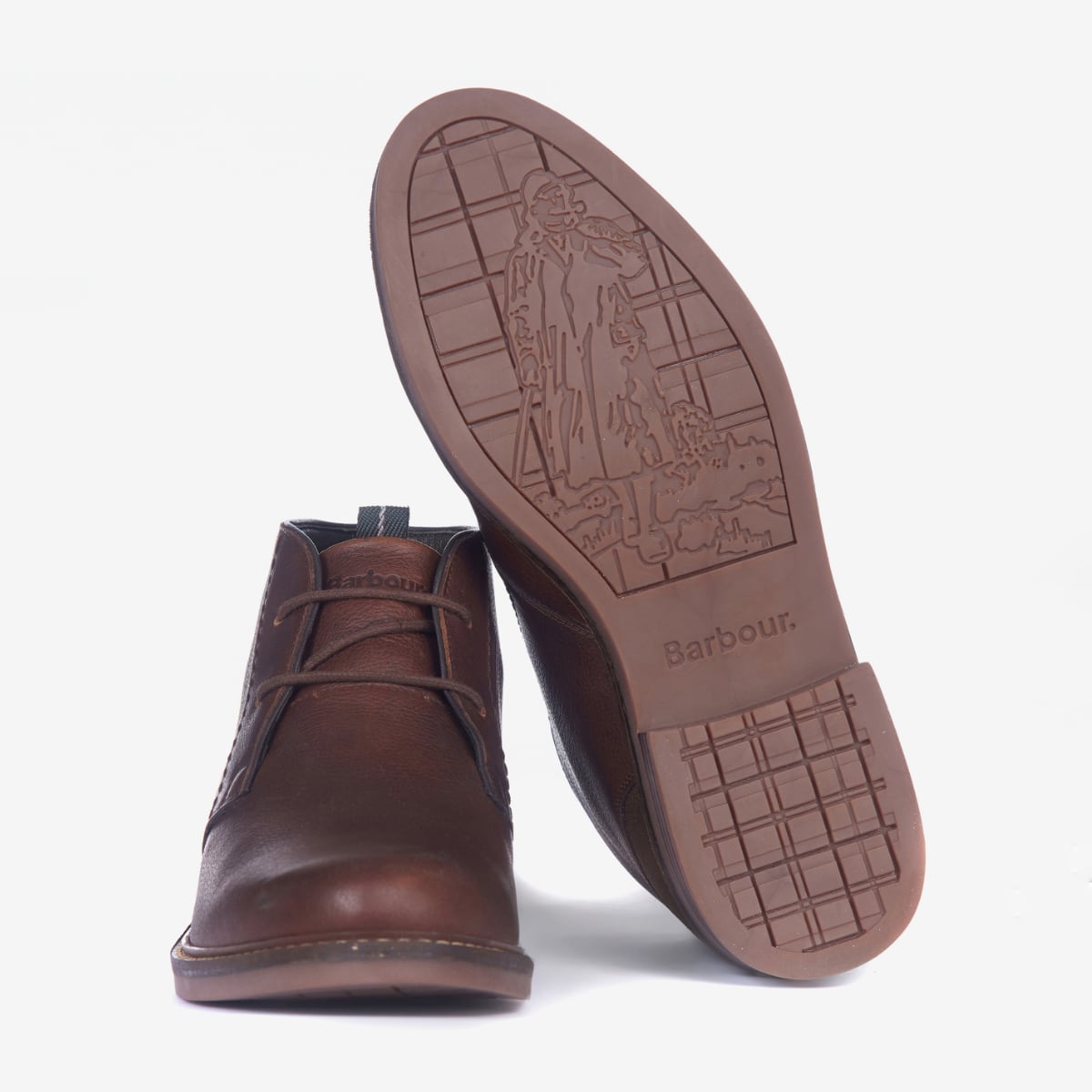A pair of Barbour Readhead Men's Chukka Boots in teak color, featuring a lace-up closure, with tartan detail on the tongue and a metal Barbour badge.