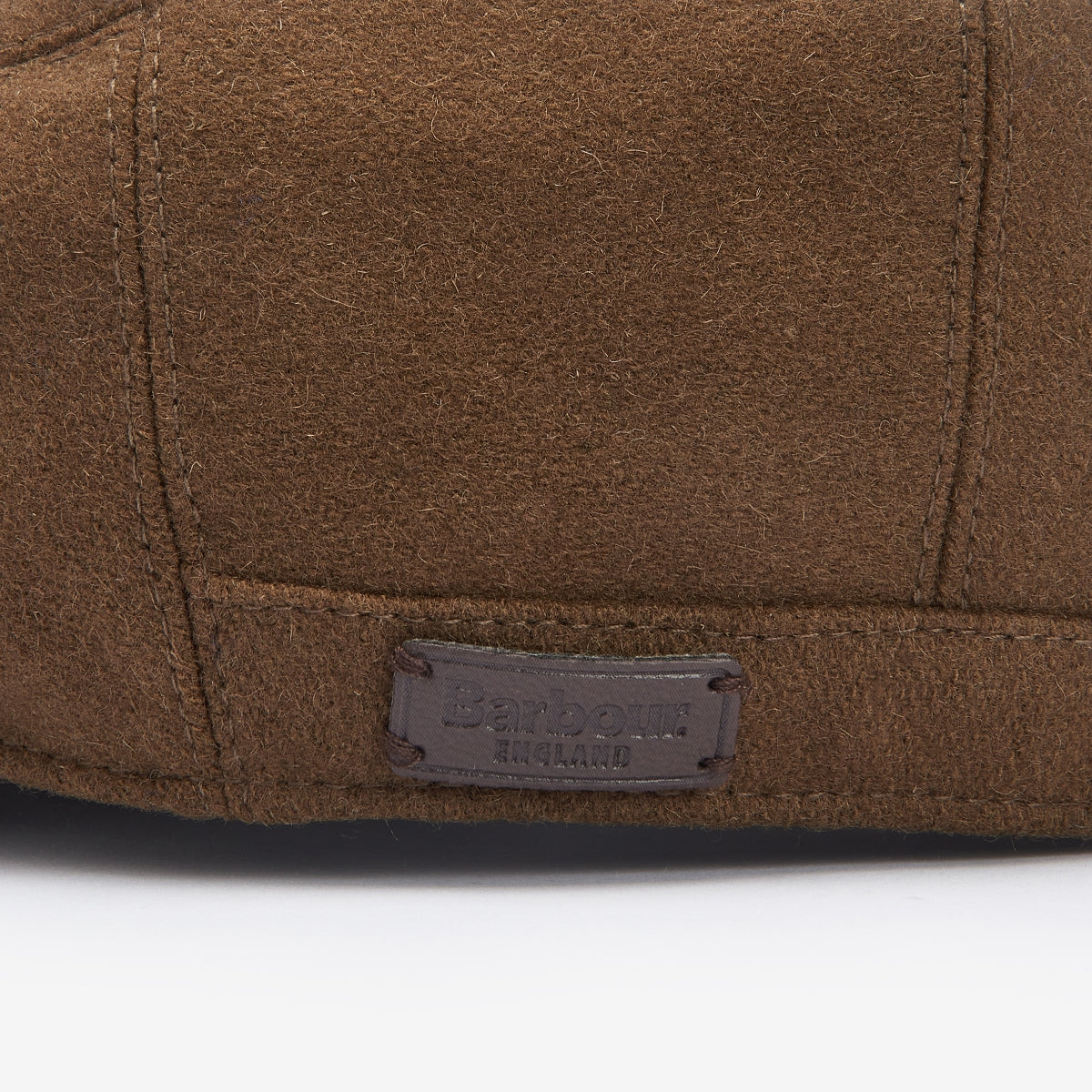 Close up of sandstone suede Barbour Redshore Cap showing stitching and leather label.