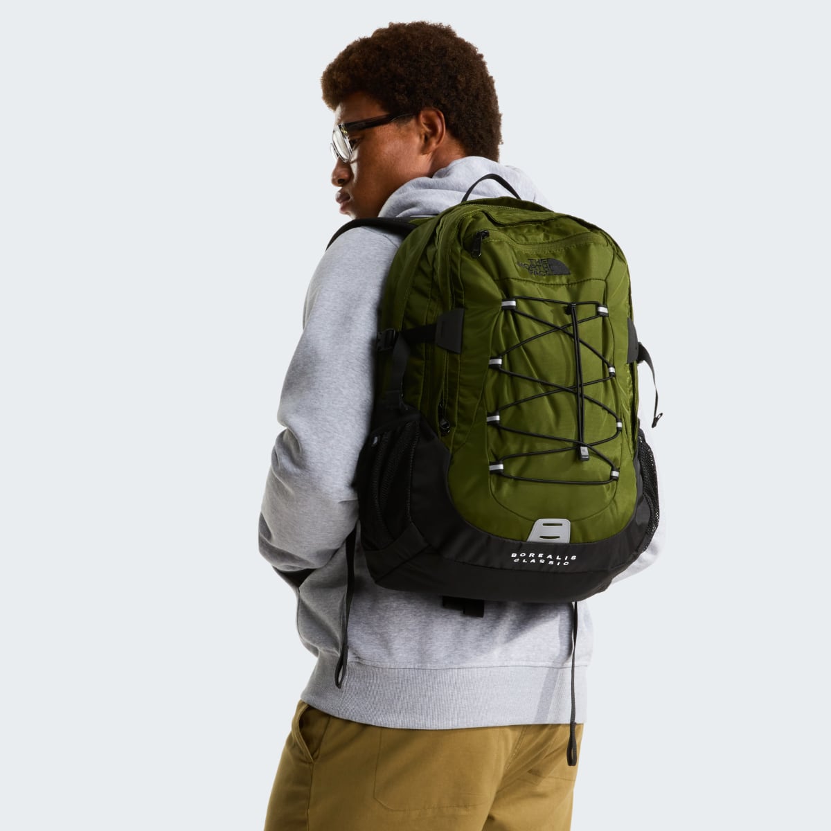 Side view of a person wearing woodland green The North Face Borealis backpack