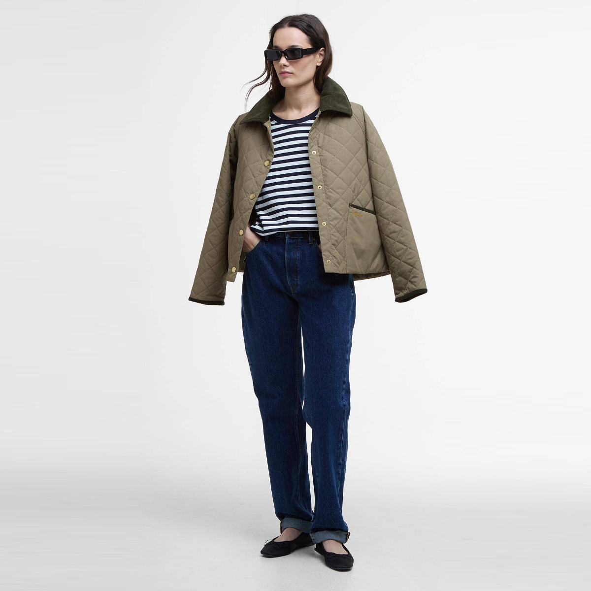 Model in an olive quilted Barbour jacket over a navy and white striped Ferryside top.