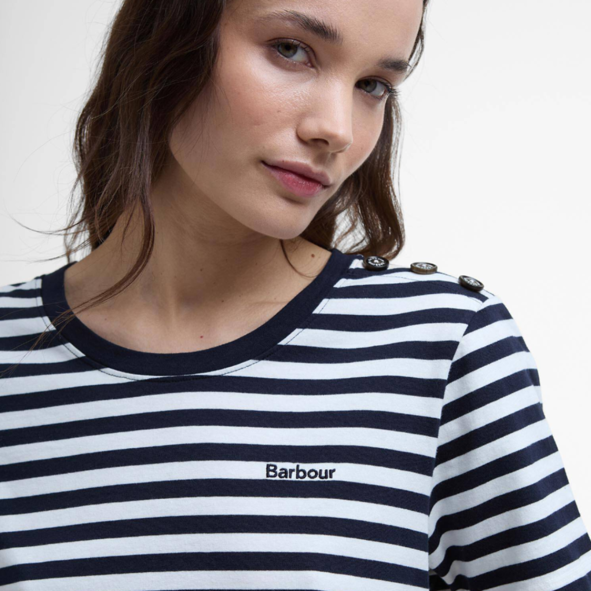 Model wearing a navy and white striped Barbour Ferryside top with shoulder button detail and Barbour logo.