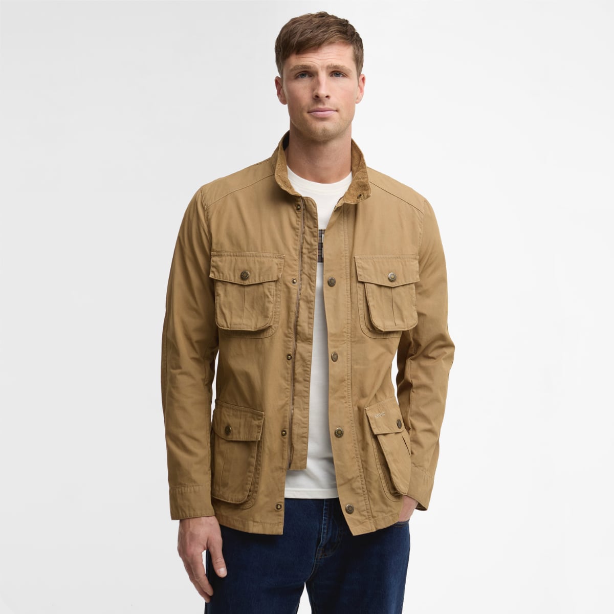 Barbour Corbridge Utility men's jacket in stone worn by model, featuring multiple flap pockets and zip front.