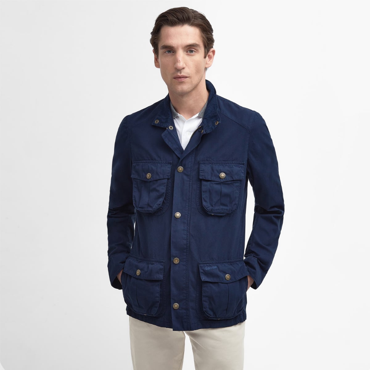 Front view of a man wearing Barbour Corbridge Utility jacket in Classic Navy with brass buttons.