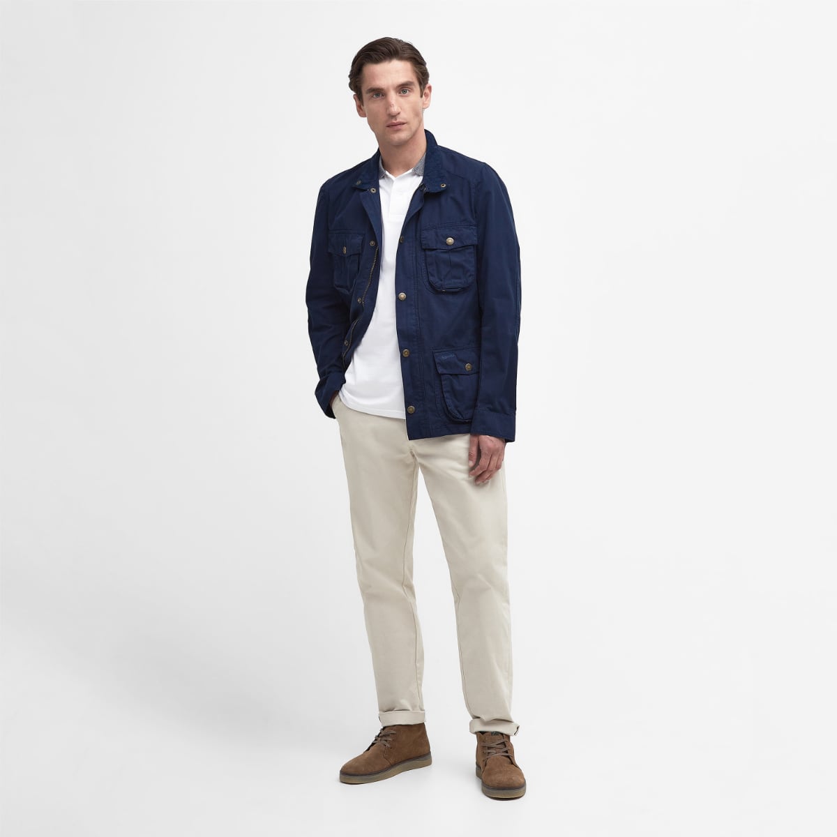 Front view of Barbour Corbridge Utility Jacket in navy worn by a male model in a white shirt and beige trousers.