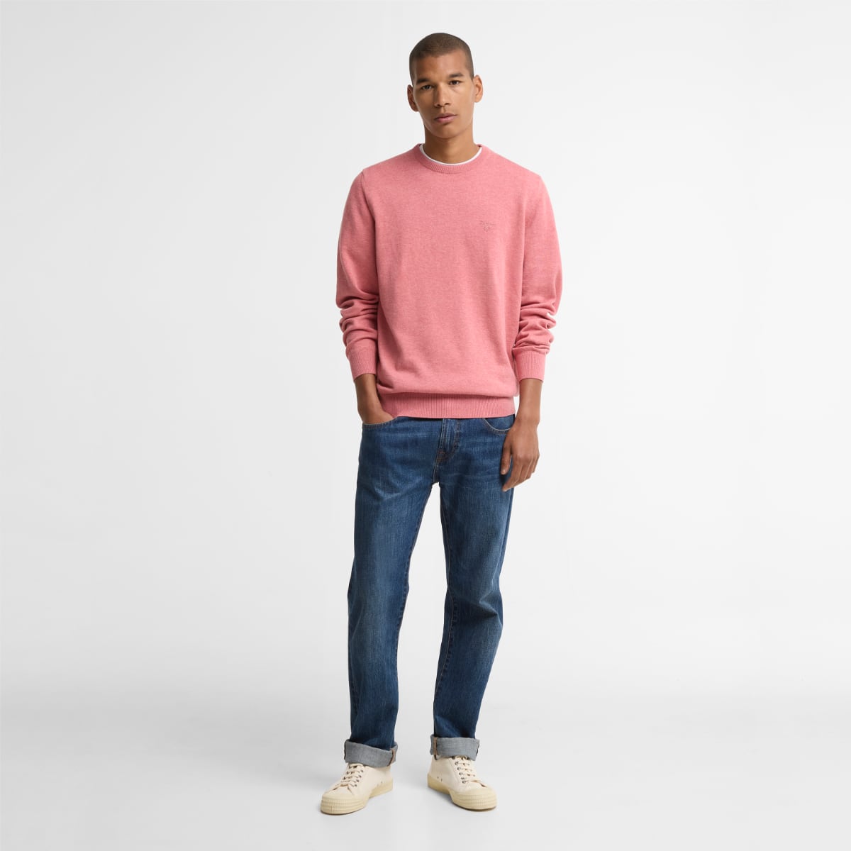 Barbour Pima cotton crew neck jumper in pink clay on male model with cuffed jeans and beige sneakers