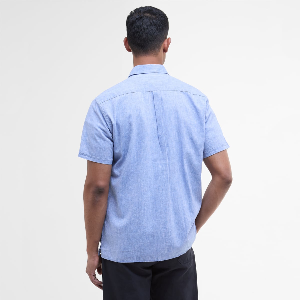 Back view of a male model wearing a light blue Barbour Nelson short sleeve shirt.