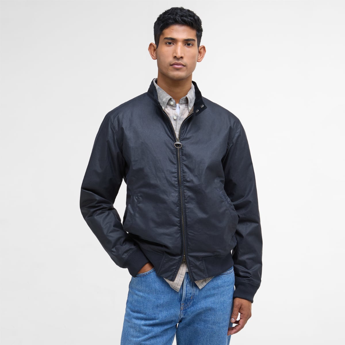 Male model wearing Barbour Lightweight Royston waxed jacket in Royal Navy navy with zip front.