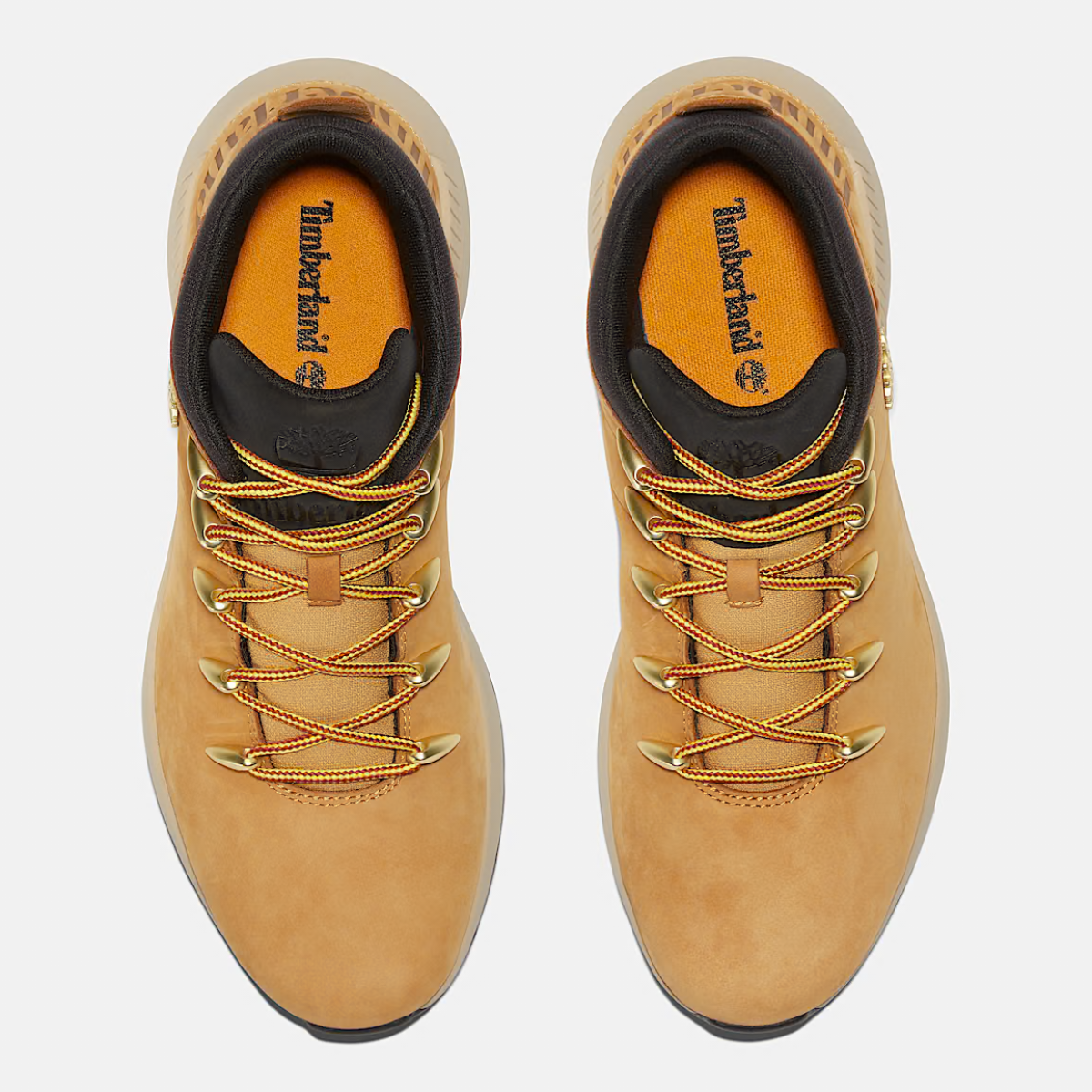 A pair of Timberland Sprint Trekker Mid Men's Boots in wheat nubuck color featuring lace-up closure and a mid-height design. Top down view.