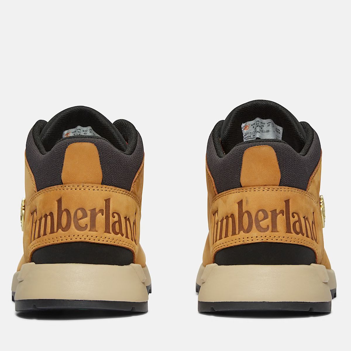 A pair of Timberland Sprint Trekker Mid Men's Boots in wheat nubuck color featuring lace-up closure and a mid-height design. Rear view.