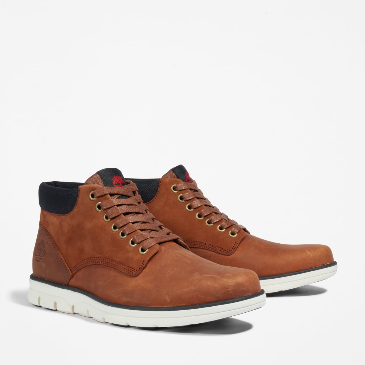 A pair of Timberland Bradstreet Chukka Men's Boots in mid-brown color, featuring a 7-eye low-cut design, stitching details, and a contrast color outsole.