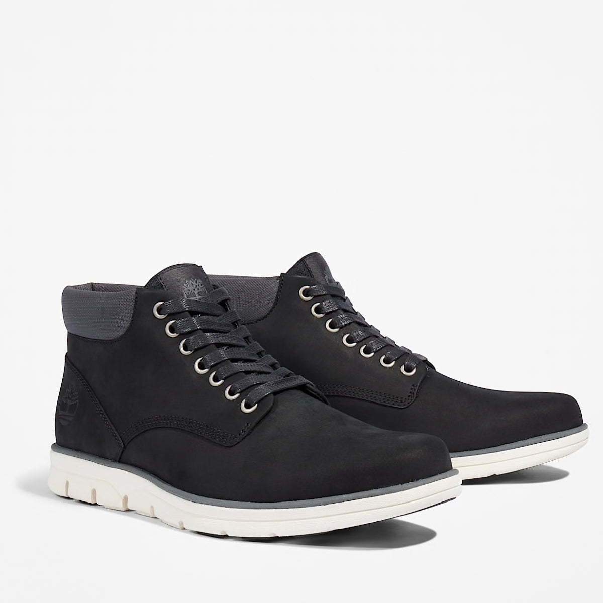 A pair of Timberland Bradstreet Chukka Men's Boots in black color, featuring a low-cut design with eyelets for laces, and a white sole.