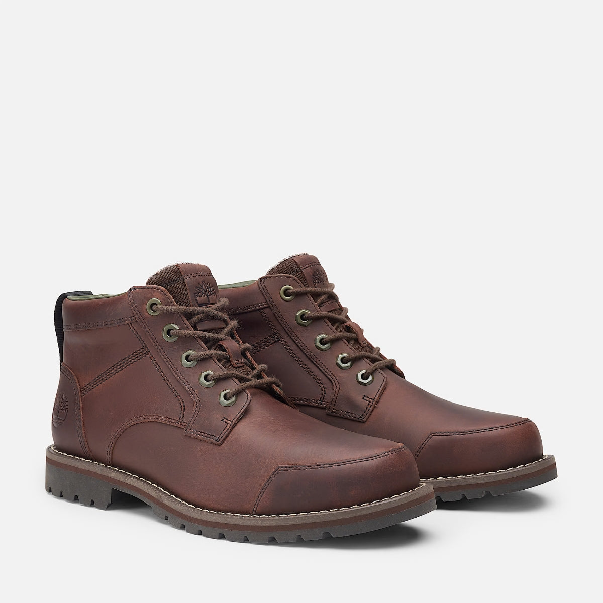A pair of Timberland Larchmont II Chukka Men's Boots in dark brown nubuck leather, featuring a lace-up front, padded collar, and a rubber cleated outsole.