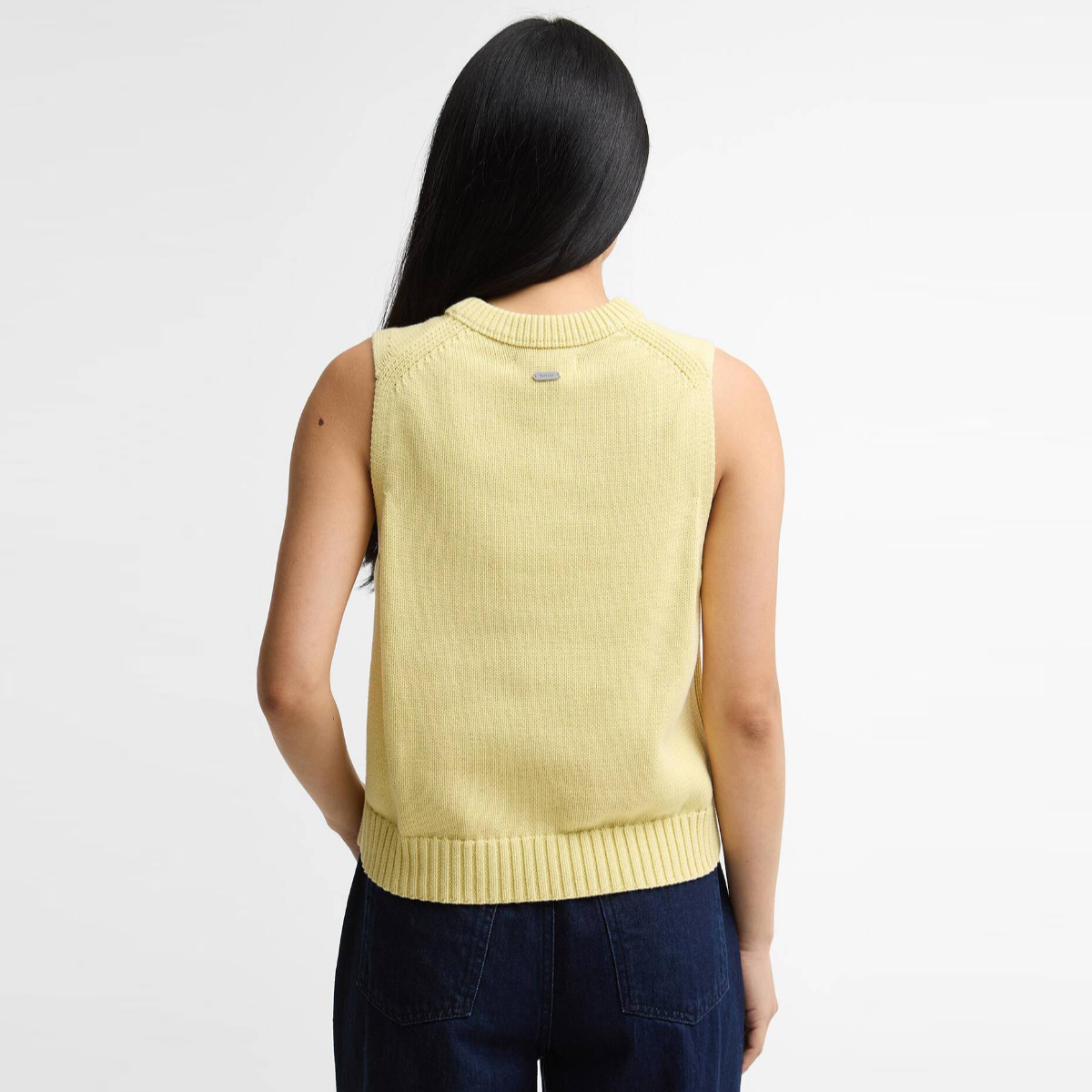 Back view of a pale yellow Barbour Avon knitted sleeveless vest worn by a model