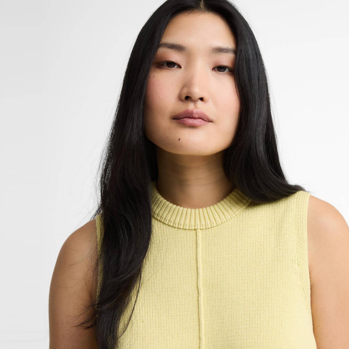Portrait of a woman wearing the soured citrus Barbour Avon knitted sleeveless vest