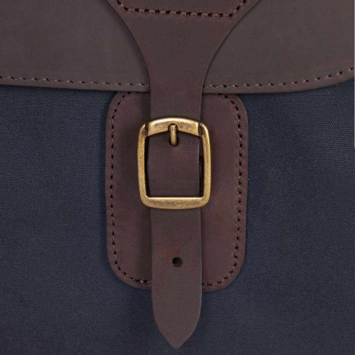 Close-up of Barbour embossed leather logo tab and buckle on the Wax Leather Briefcase