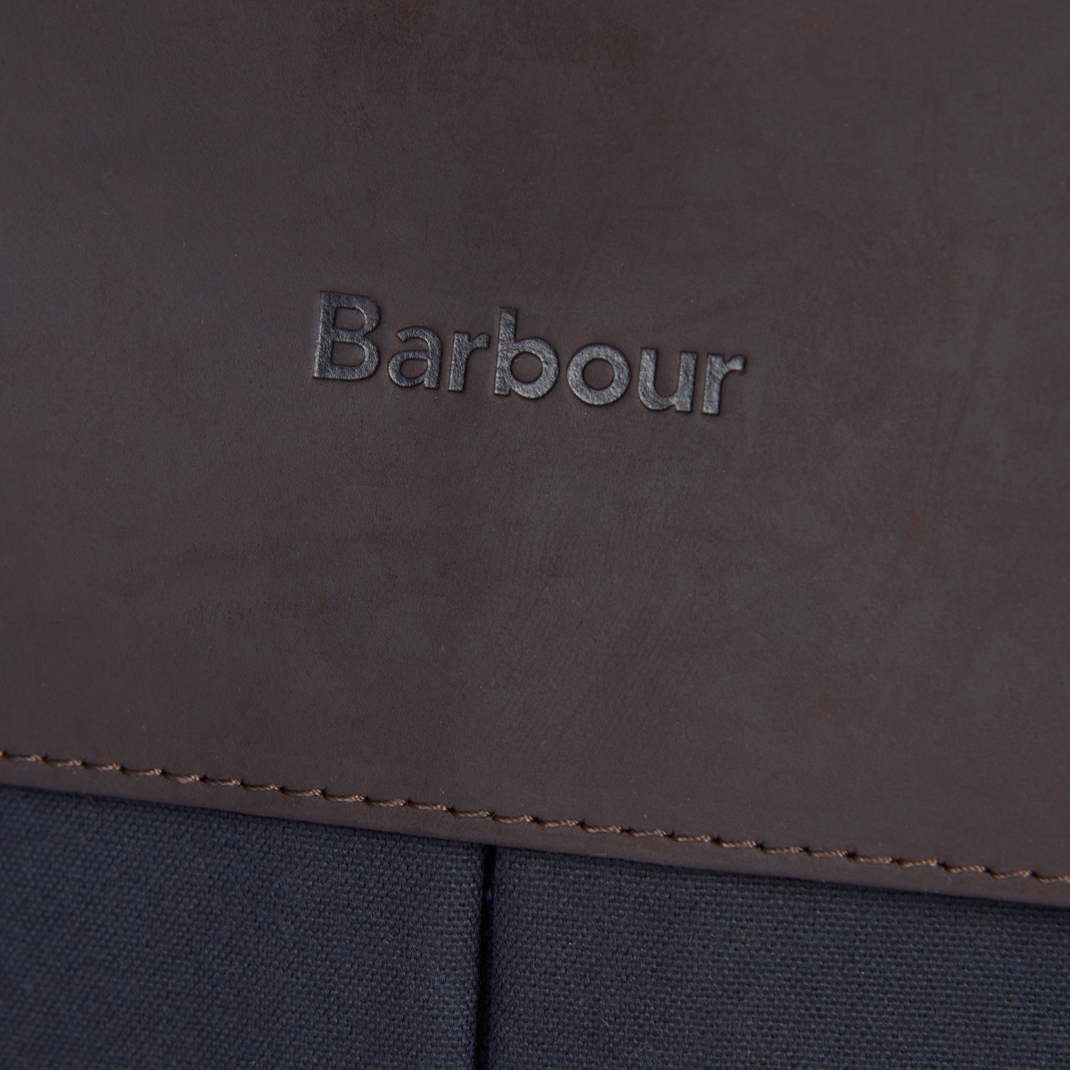 Close-up of Barbour embossed leather logo tab on the Wax Leather Briefcase
