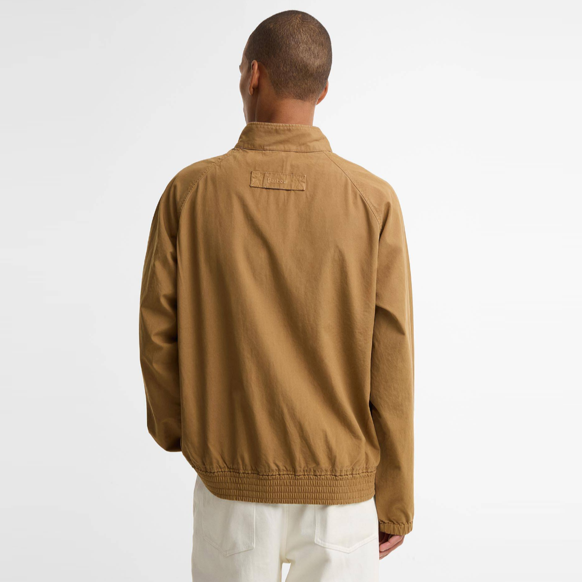 Back view of camel Barbour Royston Harrington jacket with a label patch on the upper back and a ribbed hem