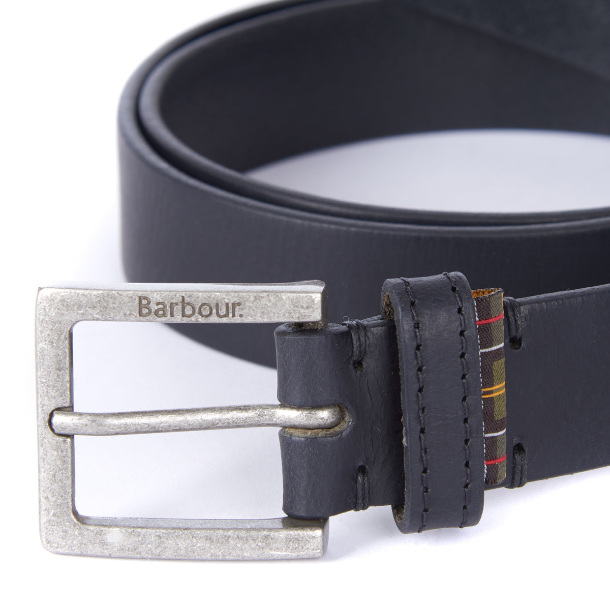 Close up of Barbour belt buckle engraved Barbour on dark leather with a plaid keeper