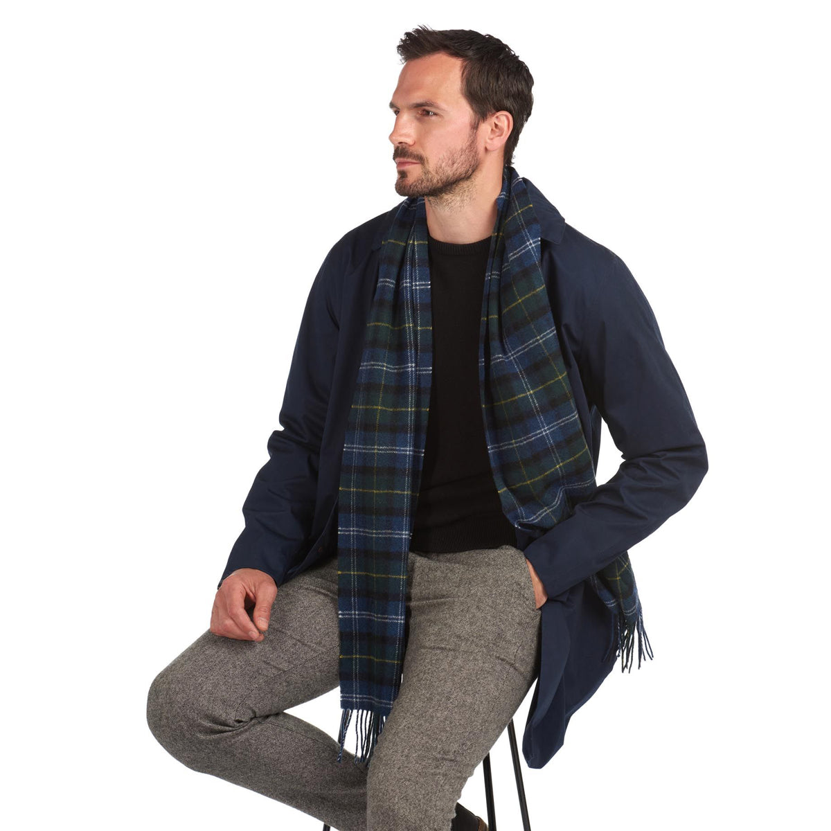 Man wearing Barbour Seaweed tartan lambswool scarf over a navy coat