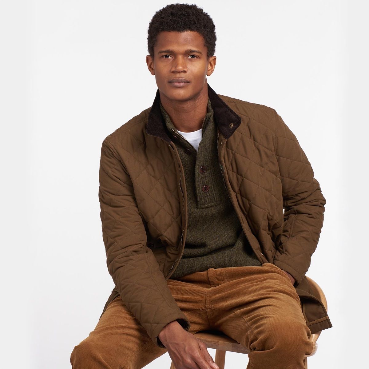 Model wearing Barbour Shoveler Jacket in Dark Sand - Sitting down