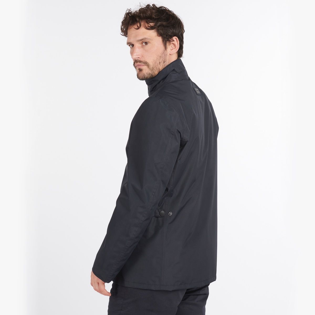 Man wearing navy Barbour Spoonbill waterproof jacket in profile view