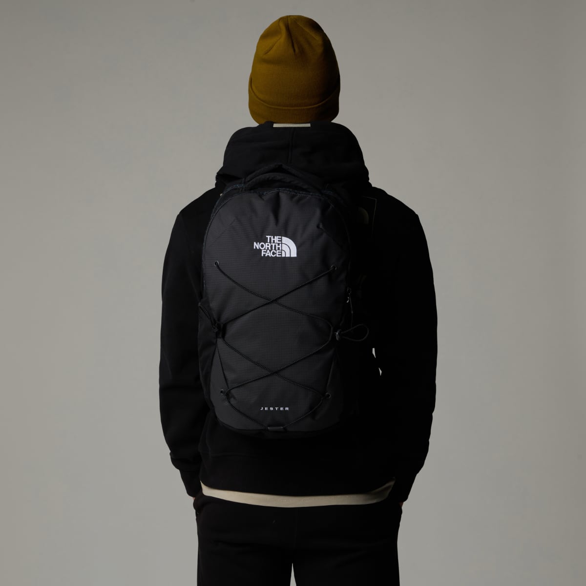 Back view of a person wearing The North Face Jester Backpack in black with a white logo