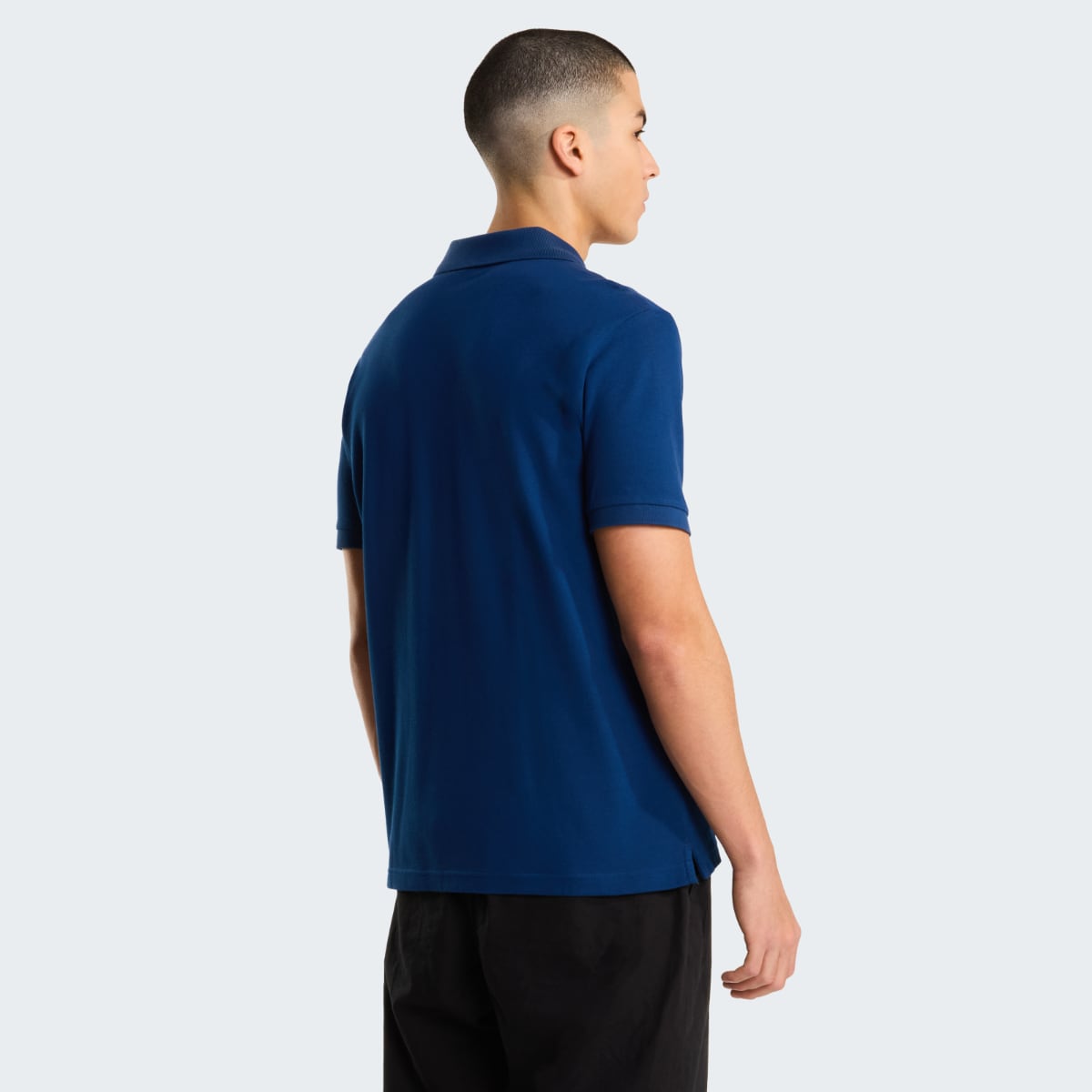 Back view of a man wearing Estate Blue The North Face Essential Regular polo shirt