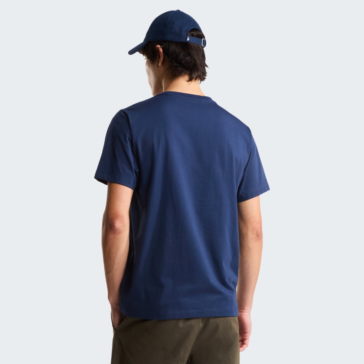 Back view of a male model wearing Summit Navy Evolution Simple Dome short sleeve t shirt with a cap and olive shorts.