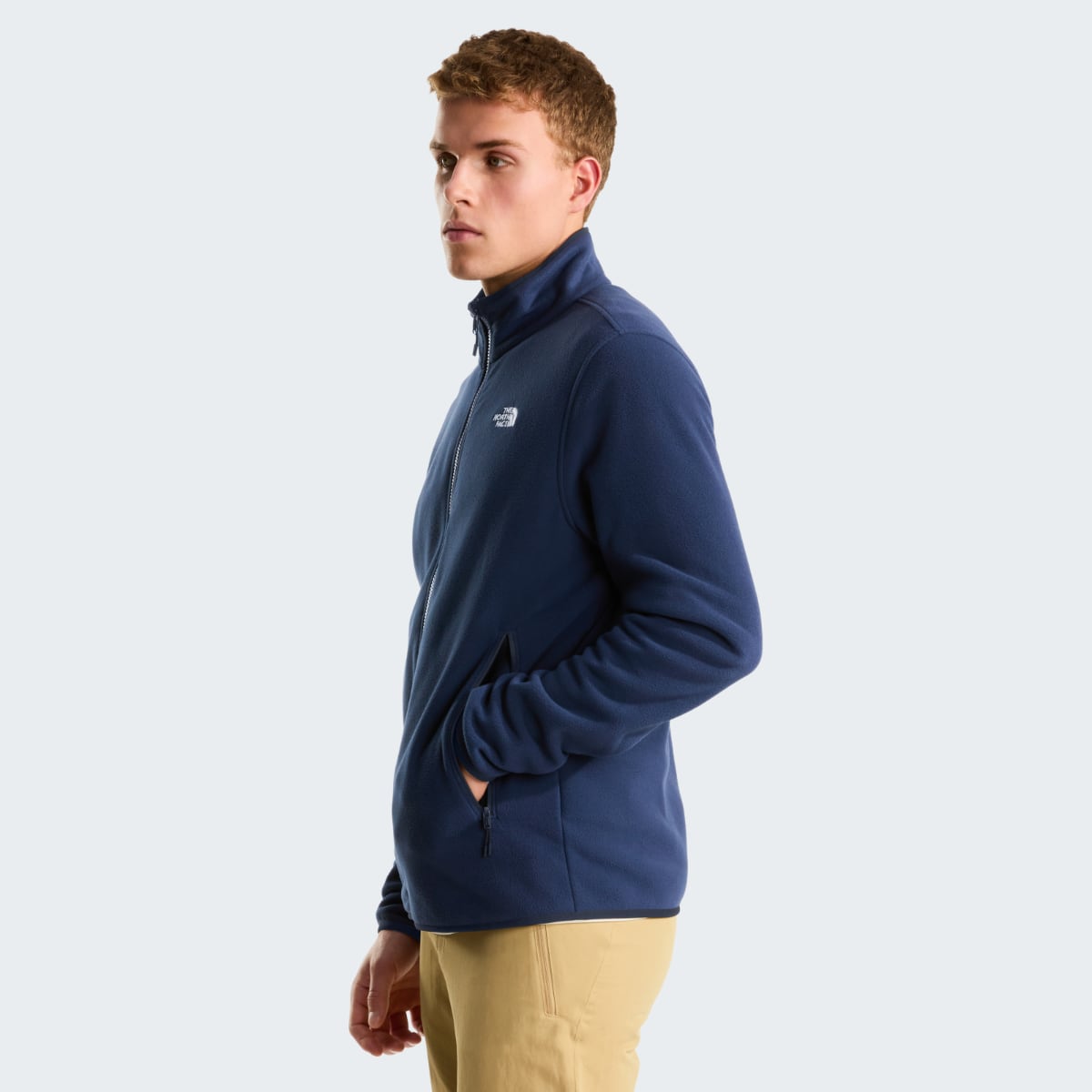 Side profile of a man wearing a navy The North Face Glacier fleece jacket with a zip front and chest logo