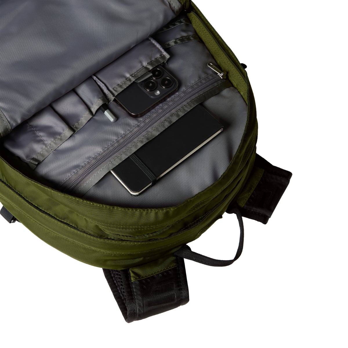 Open woodland green Borealis backpack interior with organized pockets holding a phone and notebook.