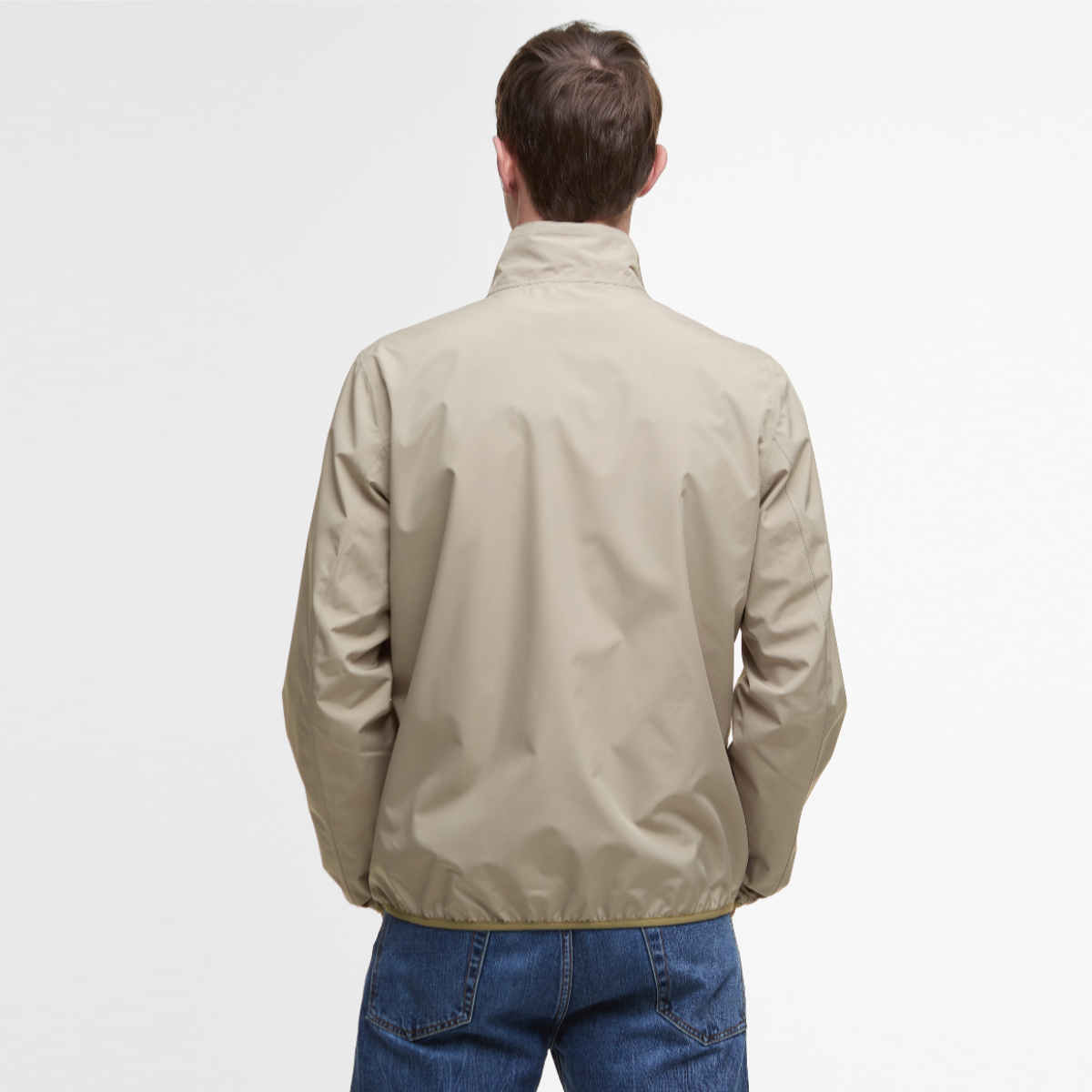 Back view of Barbour Korbel waterproof jacket in washed stone with a high collar and elastic hem