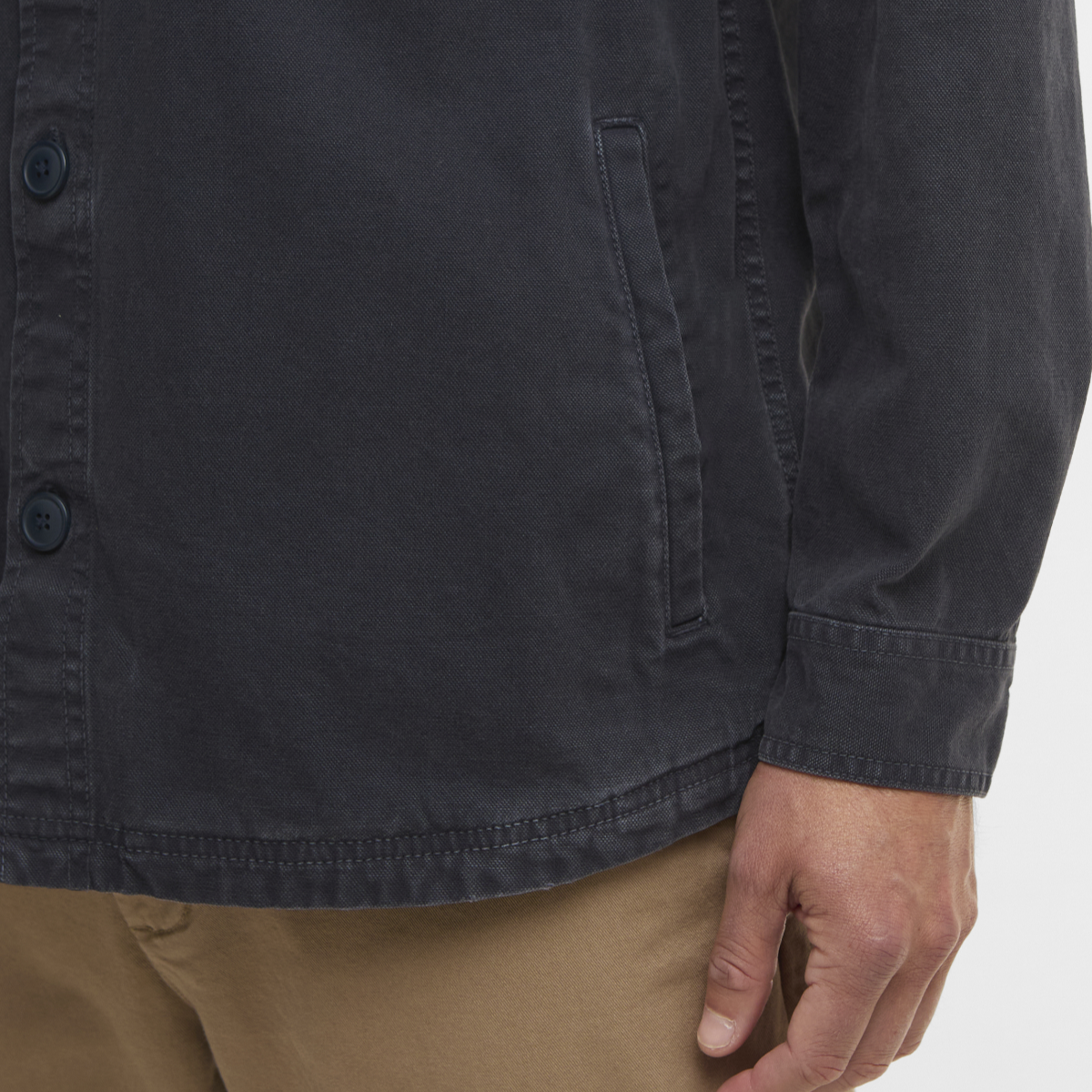 Close-up of navy Barbour Lingfield Canvas overshirt fabric with button placket and vertical front pocket.