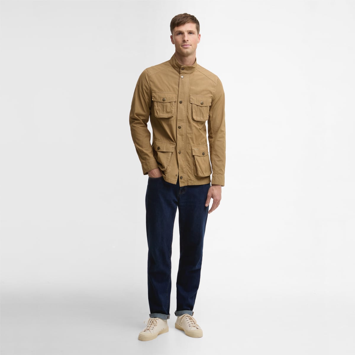 Man wearing Barbour Corbridge Utility jacket in stone, front view with four flap pockets and a standing collar