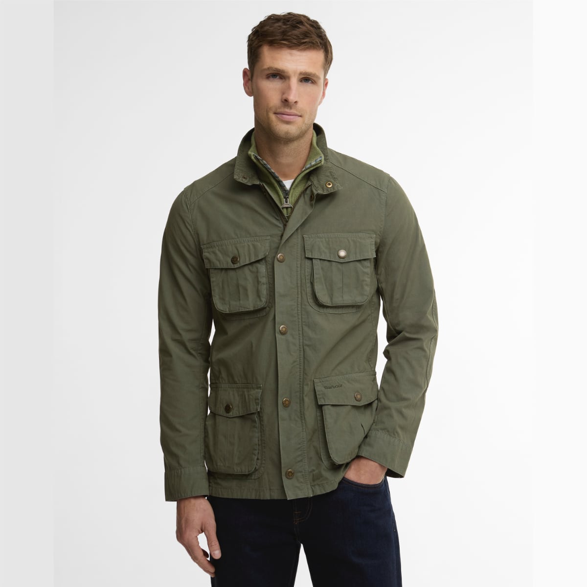Model wearing Barbour Corbridge Utility jacket in dusty olive with multiple front pockets and brass buttons