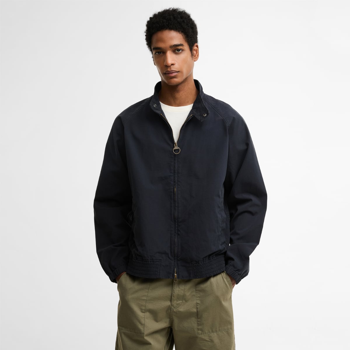 Male model wearing dark navy Barbour Royston cotton Harrington jacket with zip front and ribbed hem