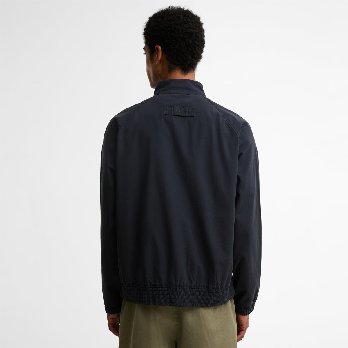 Back view of navy Barbour Royston Harrington jacket showing gathered hem and brand label