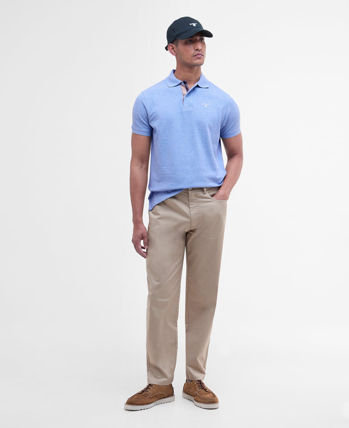 Male model wearing Barbour Tartan Pique polo in sky marl and a dark navy cap
