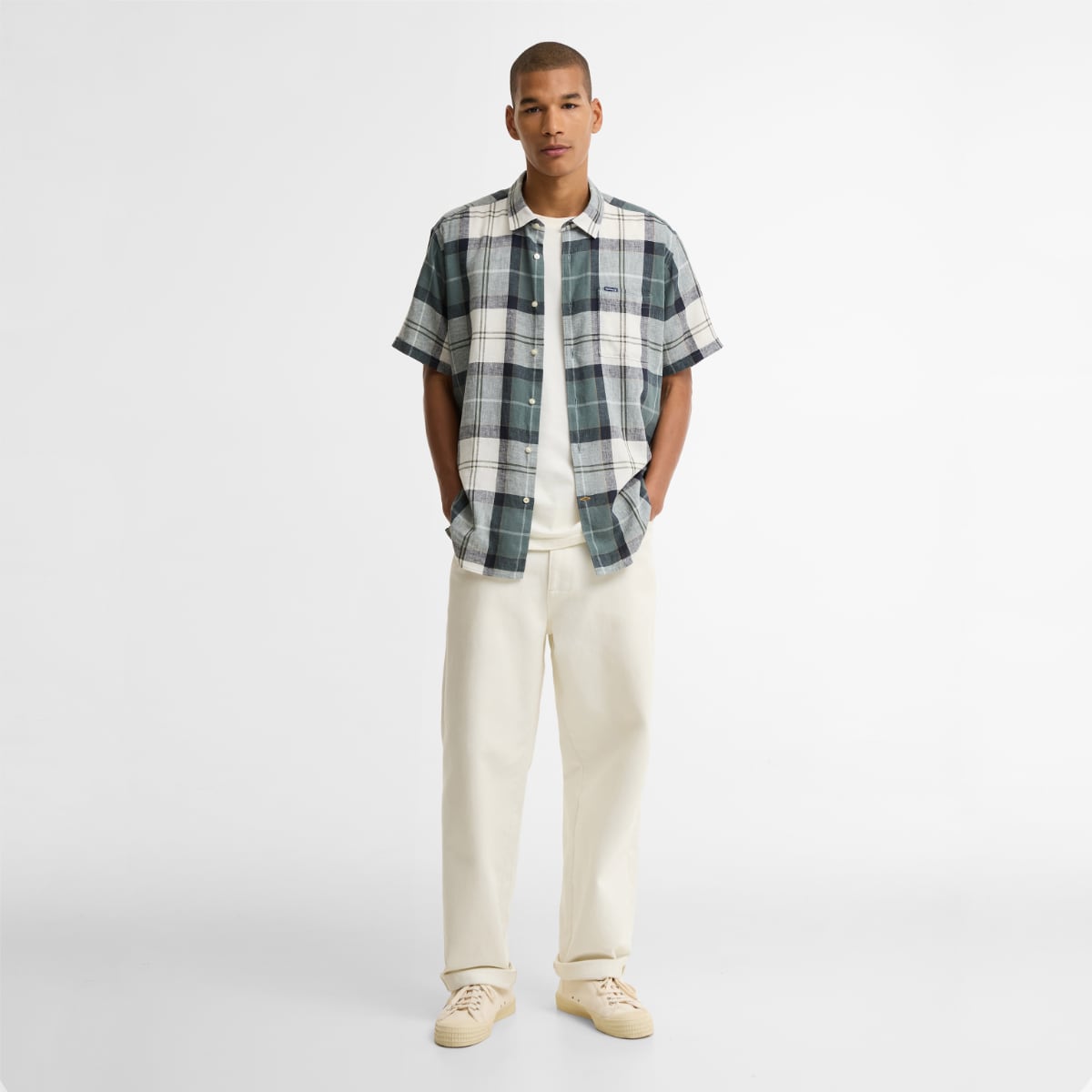 Front view of a model in Barbour Croft Tartan short-sleeve shirt worn over a white tee.