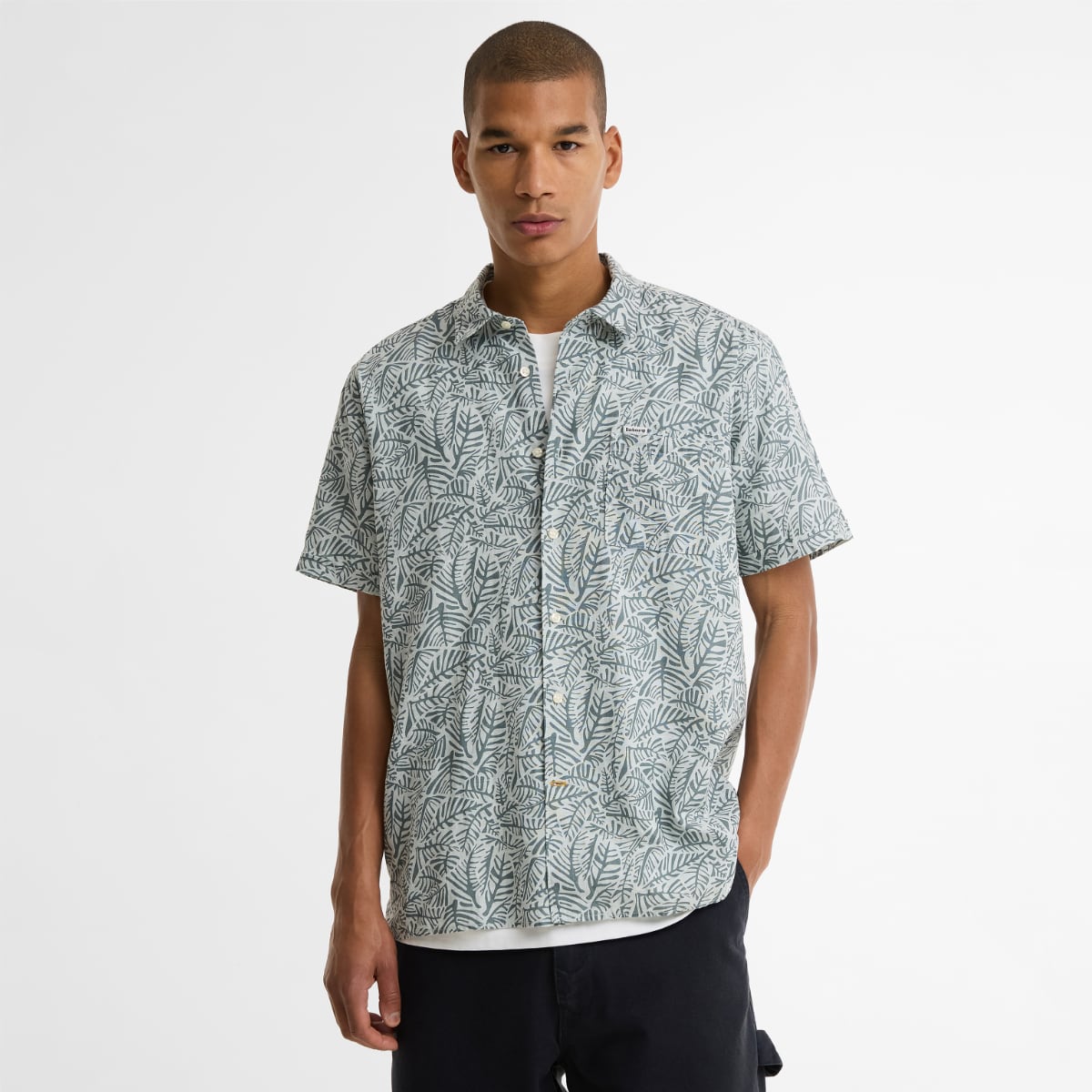 Man wearing Barbour Dearham short-sleeved relaxed-fit shirt with dusty slate leaf pattern.
