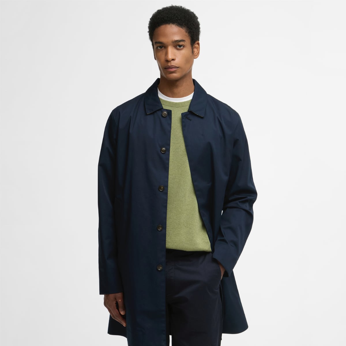 Male model wearing navy Barbour Rokig waterproof jacket over an olive knit sweater, front view