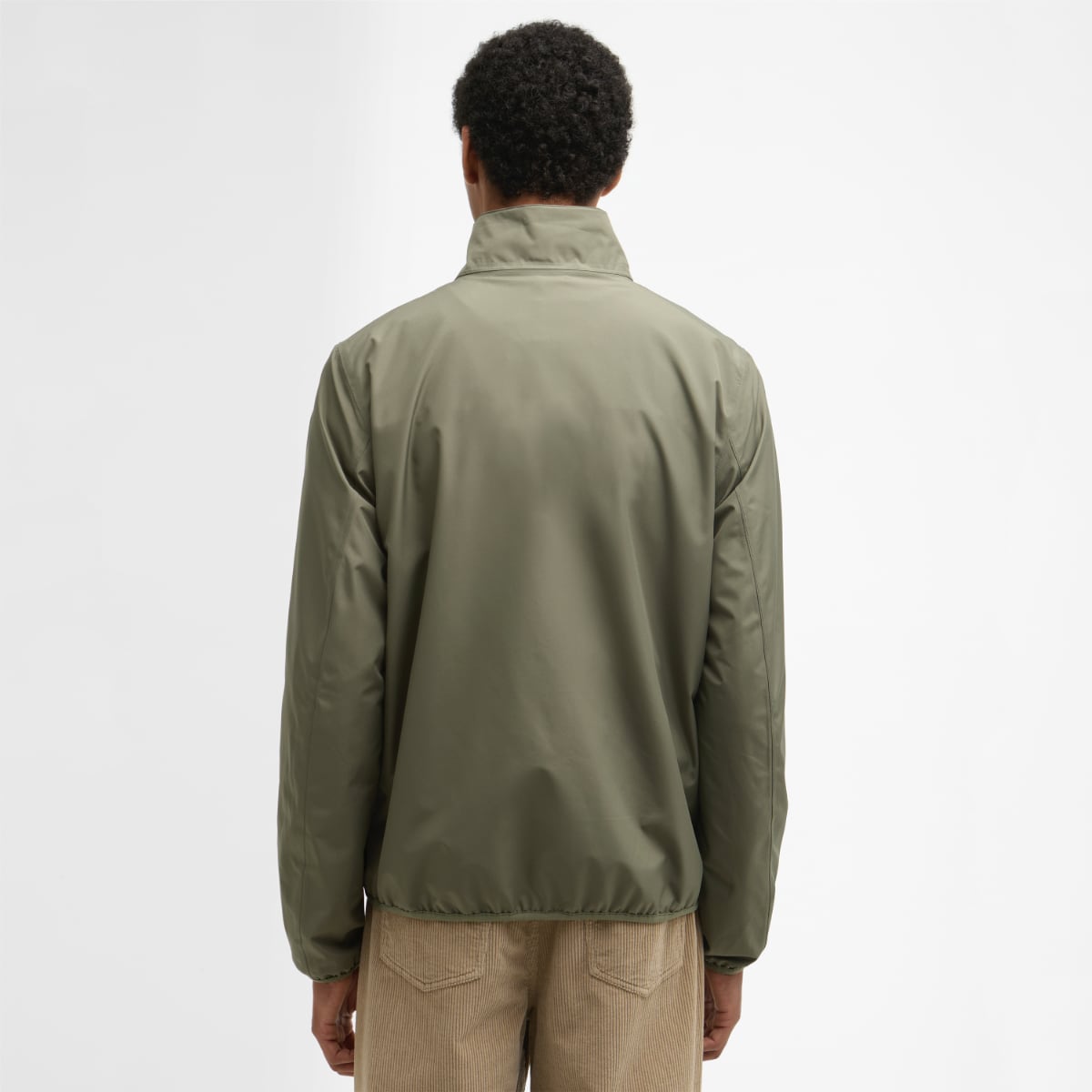 Back view of dusty olive Barbour Korbel waterproof men's jacket on a model