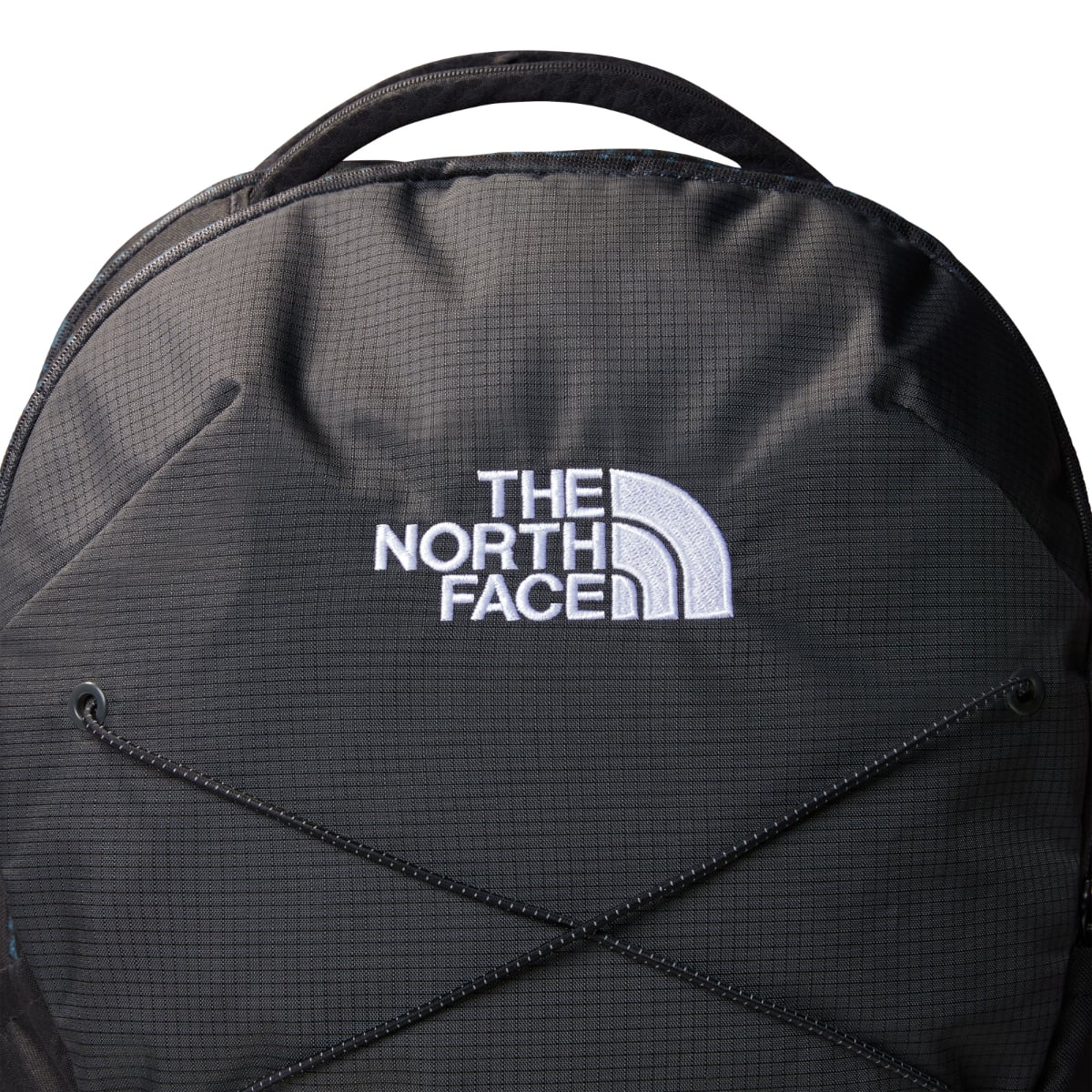 Close up of The North Face logo embroidered on black Jester backpack fabric with drawcords